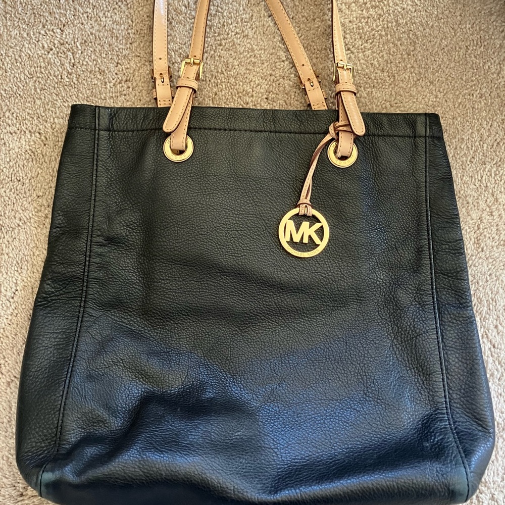 Michael Kors black leather bag with tan straps. Gold MK logo medallion